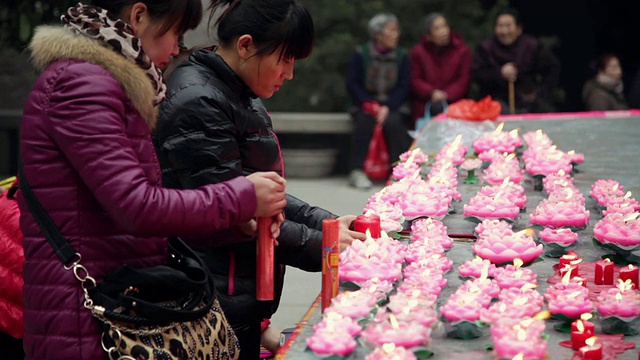 中国农历新年，陕西西安佛寺，朝圣者点燃蜡烛祈求好运视频素材