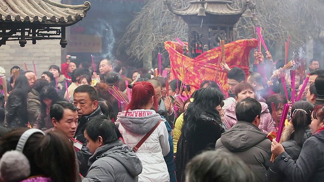 中国农历新年，在中国陕西西安的道观，香客们举起香烛，摸香炉丁丁，祈求好运视频素材