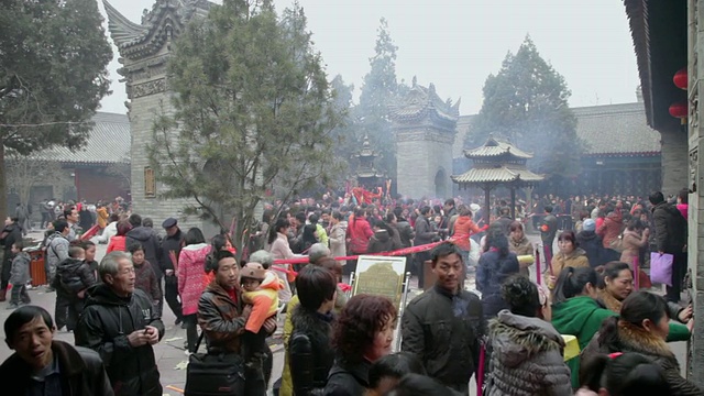 中国陕西西安，一群朝圣者在道教寺庙烧香祈求好运视频素材