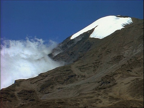 云雾缭绕，乞力马扎罗山的雪岭，映衬着蓝天，坦桑尼亚，非洲视频素材