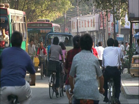 中国北京繁忙的街道上，汽车和骑自行车的人视频素材