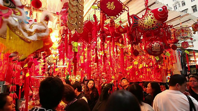 在中国香港市场，买家潘小姐走在挂着出售的酷龙前视频素材