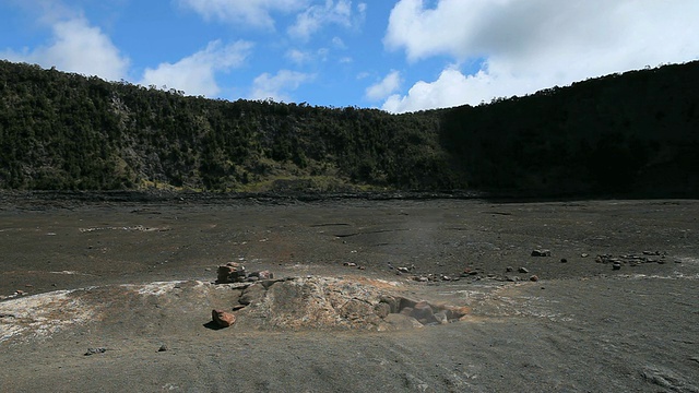 火山国家公园Kilauea Iki火山口的火山蒸汽喷口和远处被树覆盖的悬崖/夏威夷火山，大岛，美国视频素材