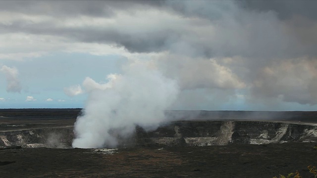 美国夏威夷大岛，火山国家公园，黑暗多云的日子里，蒸汽从基拉韦厄火山口和周围的黑色熔岩场升起视频素材