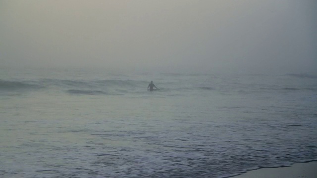 一个人在浓雾中去海里冲浪视频素材