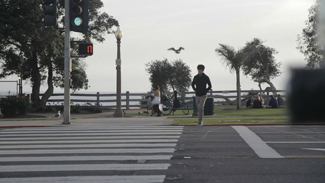 人们在人行道上行走和骑自行车，汽车在街道上行驶视频素材