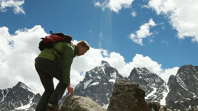 徒步旅行者穿过岩石山脊，后面有一吨尖峰视频素材