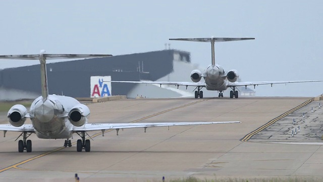 两架喷气式客机(MD-80)在跑道间滑行-远摄视角/美国德克萨斯州达拉斯沃斯堡国际机场视频素材