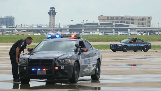 美国德克萨斯州达拉斯沃斯堡国际机场(DFW International Airport, Dallas-Fort Worth, Texas)，机场警车和官员，机场塔台和航站楼的灯光闪烁视频素材