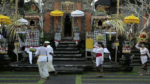 在印度尼西亚巴厘岛乌布的Pura Dalem Puri寺庙里，妇女们头上顶着供品视频素材