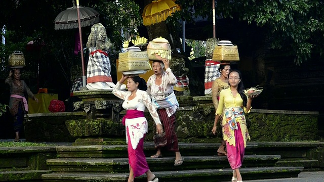 印尼巴厘岛乌布的Pura Dalem Puri寺庙里，妇女们头上顶着祭品视频素材