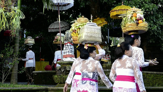 在印度尼西亚巴厘岛乌布的Pura Dalem Puri寺庙里，妇女们头上顶着供品视频素材