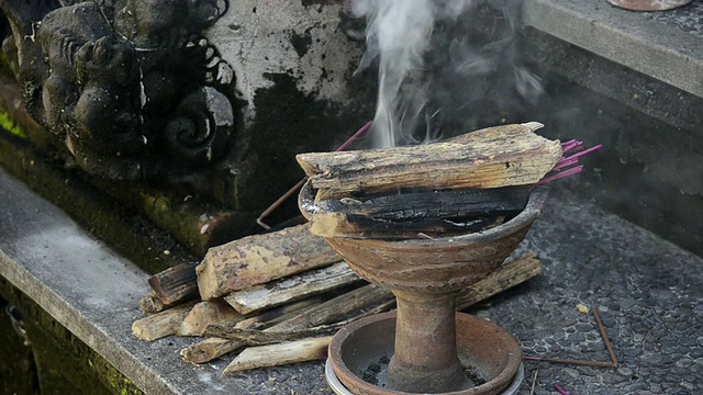 印度尼西亚巴厘岛，乌布Pura Dalem Puri寺庙，牧师将木柴放在燃烧的香炉上视频素材