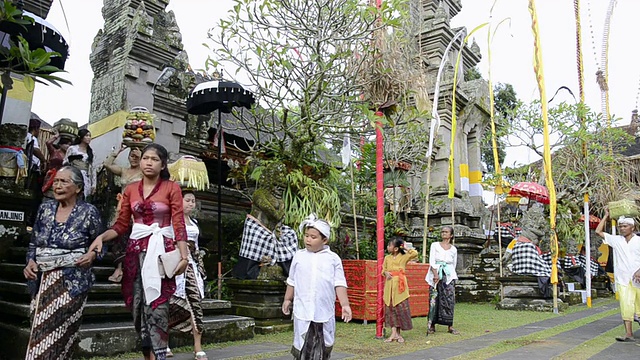 MS彩色装饰的Pura Desa寺庙仪式和妇女携带供品在她的头上，巴厘岛，印度尼西亚，亚洲视频素材