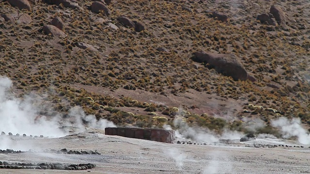 间歇泉田与蒸汽从地面和干旱的棕色和绿色的山丘/ Geiser del Tatio，阿塔卡马沙漠，智利视频素材