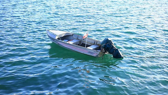 一艘小船停泊在水面上，旗帜随风飘扬/ Dalcahue, Isla Grande de ChiloÌ©，智利视频素材