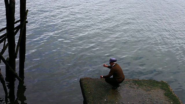 MS Fisherman蹲着拿着钓鱼线/卡斯特罗，Isla Grande de ChiloÌ©，智利视频素材