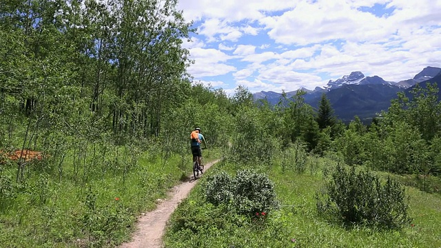 远离镜头的自行车下山的山路视频素材