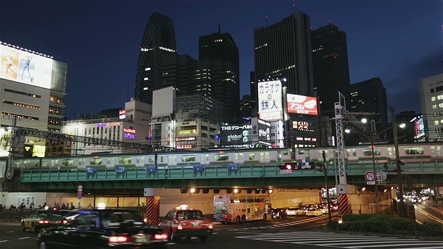 黄昏时分，日本东京新宿商业区的WS列车、车流和行人视频素材