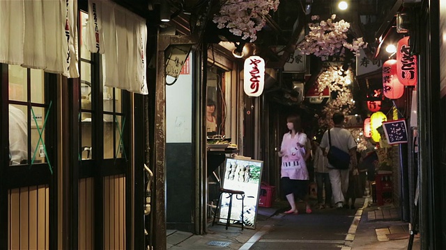 在日本东京，人们走过Omoide横街，这是一条由传统日本酒吧和餐馆组成的狭窄小巷视频素材