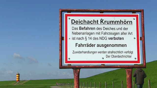 东弗里斯兰/下萨克森州北海KrummhÃ¶rn附近的Pilsum灯塔上的MS标识牌和漫步的人们视频素材