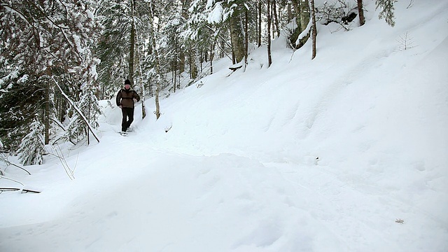 老男人穿雪鞋在小路上视频素材