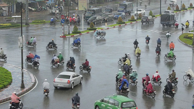 MS摄于越南西贡胡志明市大雨中的自行车、汽车和摩托车街道交通视频素材