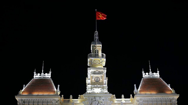 MH LA LD越南国旗在夜晚从越南市政厅顶部飘扬/越南视频素材