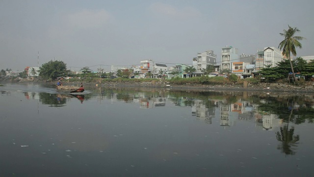 船POV WS船在水上漂浮，岸边有建筑物/会安，越南视频素材