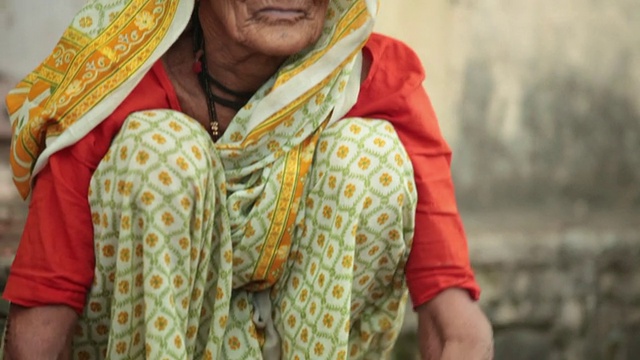 印度马哈拉施特拉邦，Malshej Ghat，一位老妇人正在把洋葱放进篮子里视频素材