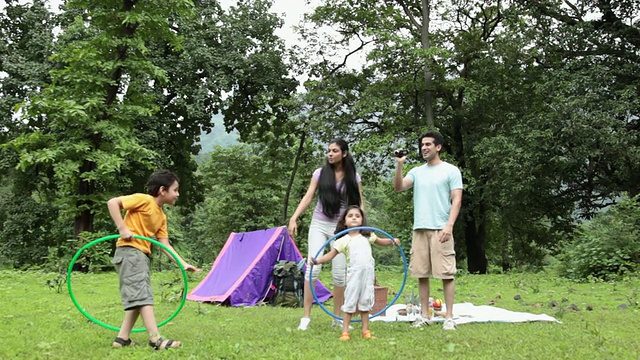 印度马哈拉施特拉邦Malshej Ghat，一家人在森林里玩呼啦圈视频素材