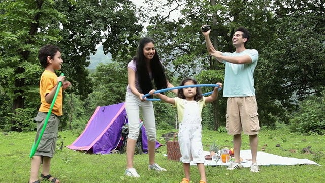 印度马哈拉施特拉邦Malshej Ghat，一家人在森林里玩呼啦圈视频素材