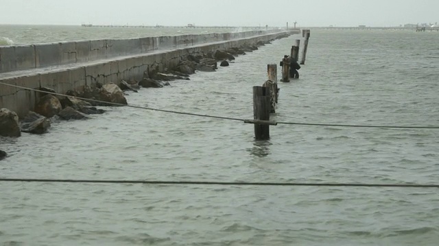 海浪冲击着码头上的断路器。视频素材