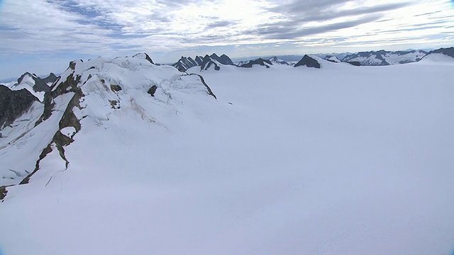 锯齿状的山峰耸立在阿拉斯加白雪覆盖的山谷之上。/阿拉斯加,美国的视频素材