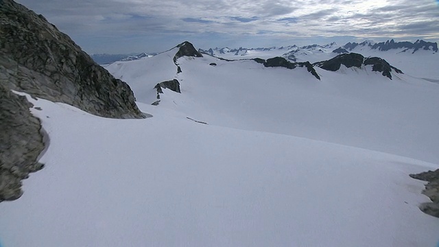 深雪覆盖着阿拉斯加锯齿状的山峰和山脊。/阿拉斯加,美国的视频素材