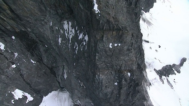 中远镜头空中倾斜向下跟踪-雪覆盖了阿拉斯加崎岖的冰川山脉。/阿拉斯加,美国的视频素材