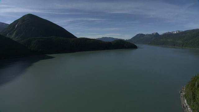 一条宽阔、平静的河流流过阿拉斯加森林密布的群山。/阿拉斯加,美国的视频素材