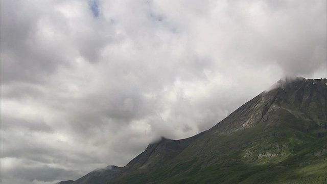 宽镜头静态风暴云快速漂移在陡峭的岩石山。/阿拉斯加,美国的视频素材