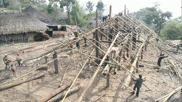 高角度静电-村民在埃塞俄比亚用木杆建造一个新的建筑。/印度视频素材