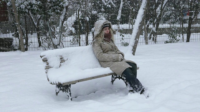 坐在暴风雪下的女人视频素材