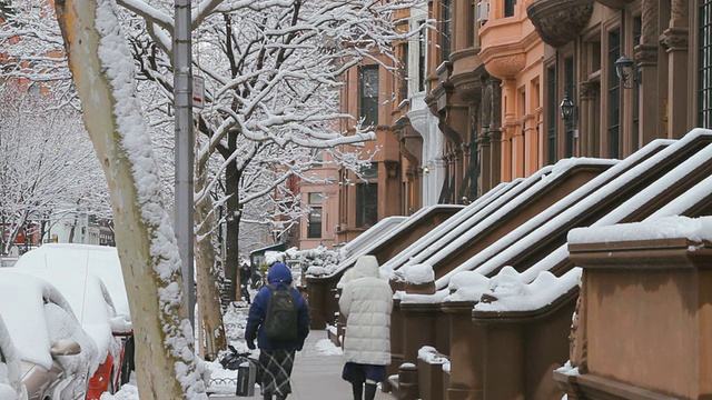 TS褐石屋在下雪的街道-人们走在人行道上/布鲁克林，纽约，美国视频素材