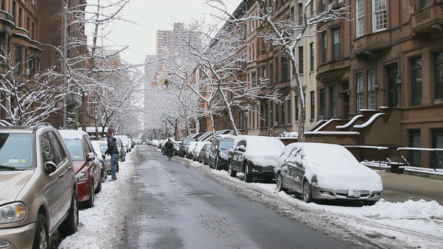 美国纽约布鲁克林，布朗斯通女士在下雪的街道上，行人在清理停在路边的积雪视频素材