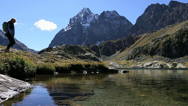 徒步旅行者到达mtn湖的低视野，拍照视频素材