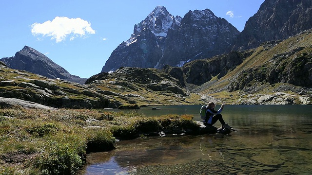 潘下山，徒步旅行者到达mtn湖，拍照视频素材