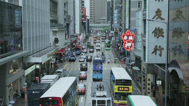 在英国大伦敦的金丝雀码头/伦敦，交通通过建筑物的道路视频素材