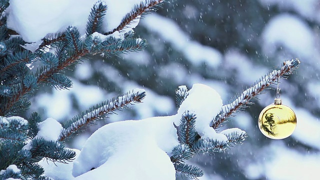 雪花轻轻地飘落在挂在树上的圣诞装饰品上视频素材