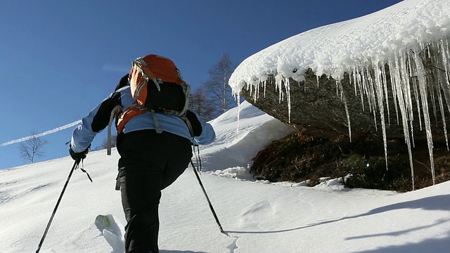 潘就像滑雪登山运动员爬上雪坡，走过冰柱视频素材