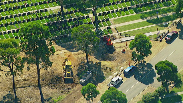 MS AERIAL DS View of traffic moving on road through cemetery and workers working for new cemetery / Sydney, new South Wales, Australia . MS AERIAL DS View of traffic moving on road through cemetery and workers working for new cemetery / Sydney, new South Wales, Australia .澳大利亚新南威尔士视频素材