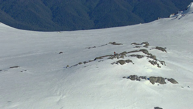 澳大利亚新南威尔士州国王悬崖上白雪覆盖的山脉上的男人的WS AERIAL ZO视图视频素材