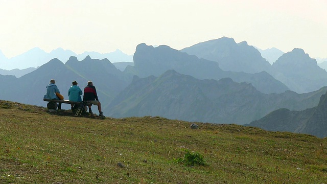 图为一名登山者在德国巴伐利亚的内伯霍恩山(Mount Nebelhorn)欣赏美景的照片视频素材